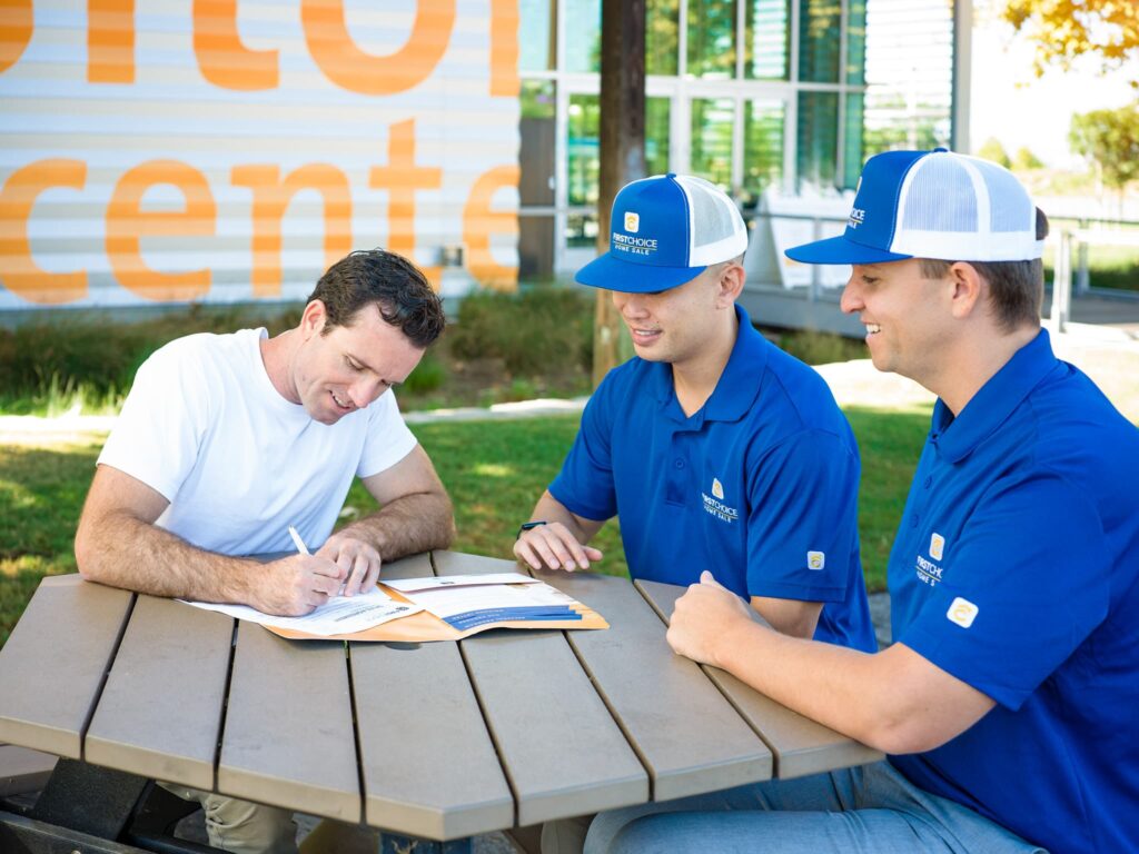 first choice home sale team signing docs with customer